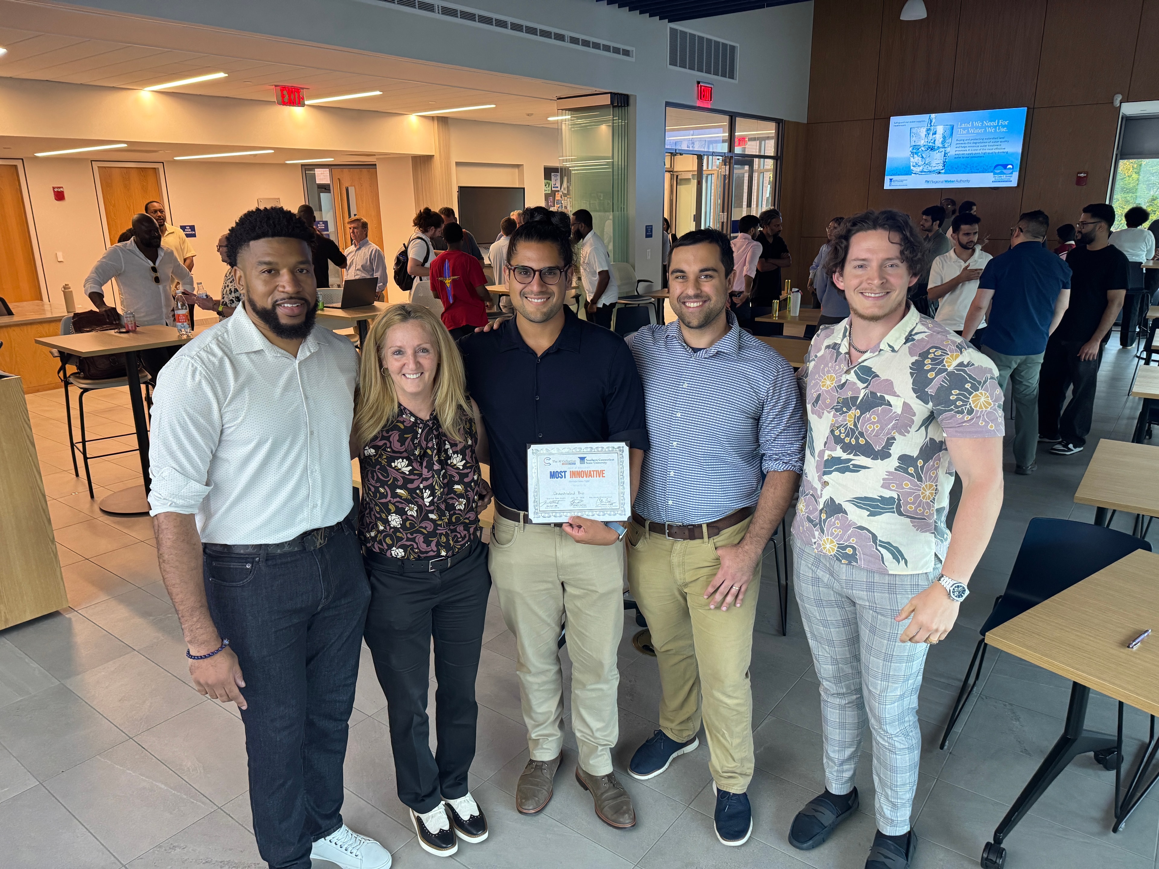 Group holding award certificate at ceremony